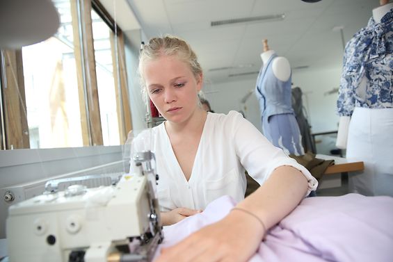 Ein Mädchen arbeitet an einer Nähmaschine